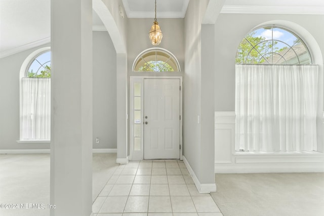 carpeted entryway featuring ornamental molding and a healthy amount of sunlight