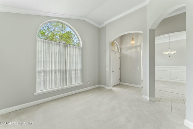 unfurnished room featuring a chandelier, light colored carpet, vaulted ceiling, and ornamental molding