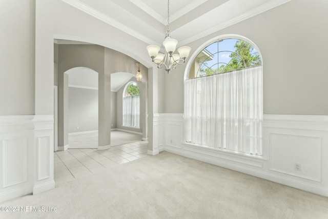 unfurnished dining area featuring crown molding, light colored carpet, and an inviting chandelier