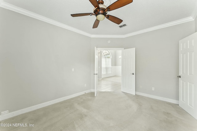 unfurnished bedroom featuring ceiling fan, light colored carpet, and ornamental molding