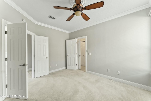 unfurnished bedroom featuring ceiling fan, crown molding, and light carpet