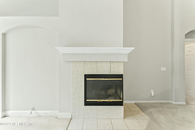 details featuring a tile fireplace and carpet