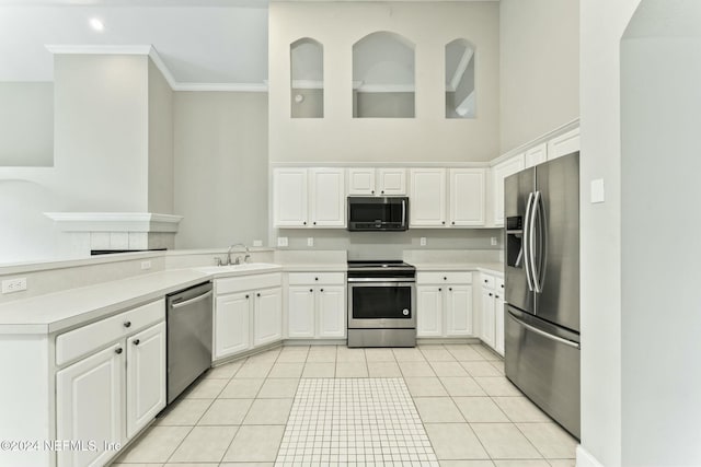 kitchen with sink, light tile patterned floors, ornamental molding, white cabinetry, and stainless steel appliances