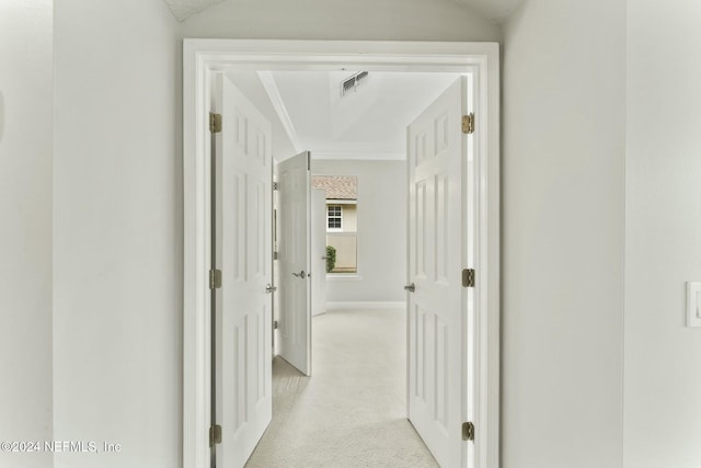 hall with light colored carpet and vaulted ceiling