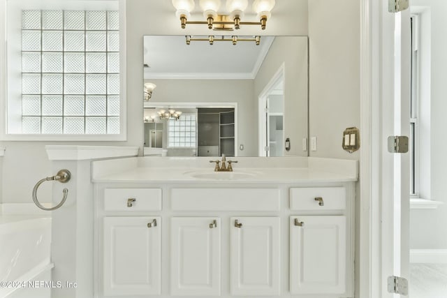 bathroom with vanity, ornamental molding, a washtub, and a chandelier