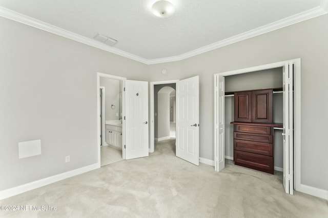 unfurnished bedroom featuring a textured ceiling, light colored carpet, ensuite bath, and ornamental molding