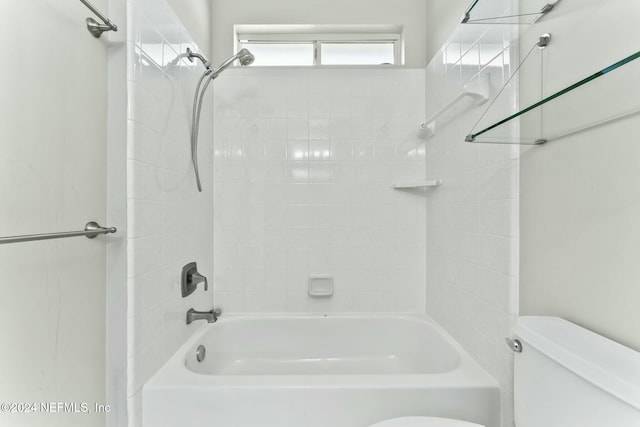 bathroom featuring tiled shower / bath combo and toilet