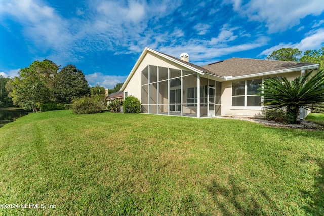 back of property featuring a yard and a sunroom