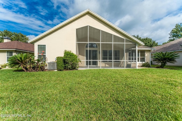 rear view of house with a lawn and central AC