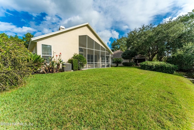 view of yard featuring a sunroom and central air condition unit