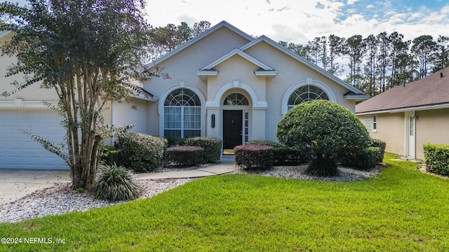 view of front of property with a front yard and a garage