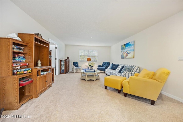 living area featuring baseboards and light colored carpet