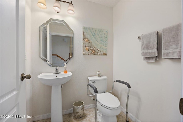 bathroom featuring tile patterned floors, a sink, toilet, and baseboards