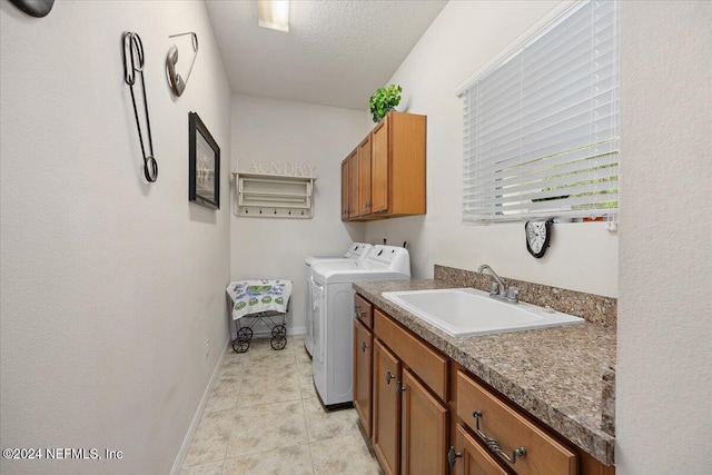 clothes washing area featuring a textured ceiling, light tile patterned flooring, a sink, cabinet space, and washing machine and clothes dryer