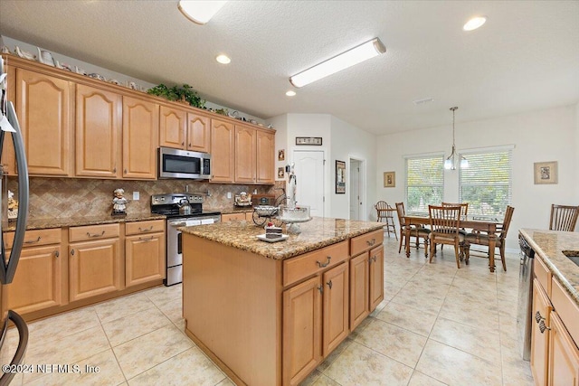 kitchen with a center island, hanging light fixtures, light stone countertops, stainless steel appliances, and backsplash