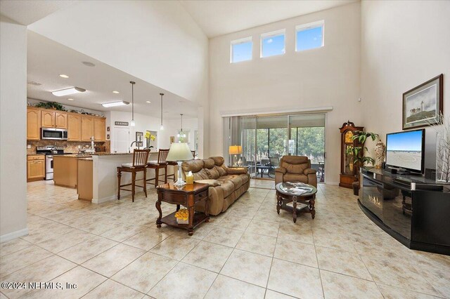 living area featuring light tile patterned floors and baseboards