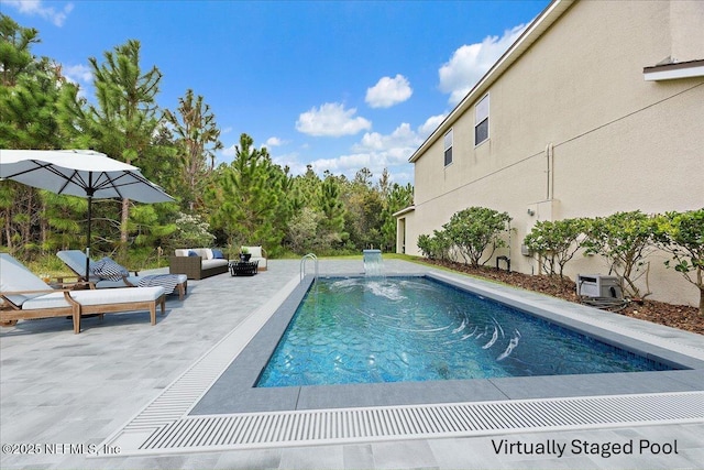 pool with an outdoor hangout area and a patio