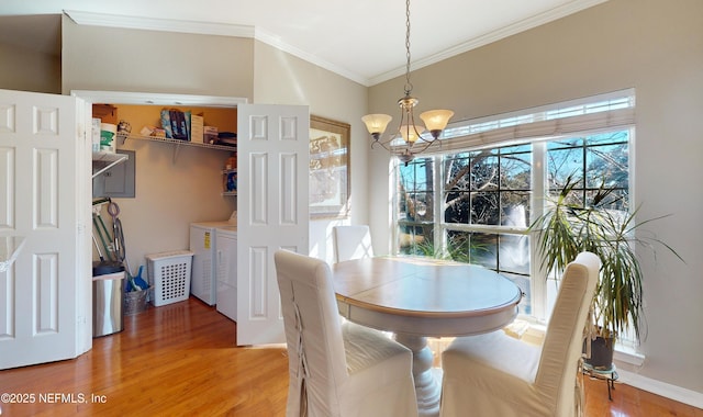 dining space featuring ornamental molding, washer and dryer, hardwood / wood-style floors, and a notable chandelier