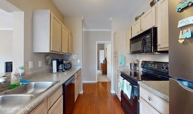 kitchen with sink, light hardwood / wood-style floors, black appliances, crown molding, and light brown cabinets