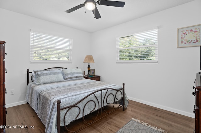 bedroom with hardwood / wood-style floors, ceiling fan, and multiple windows