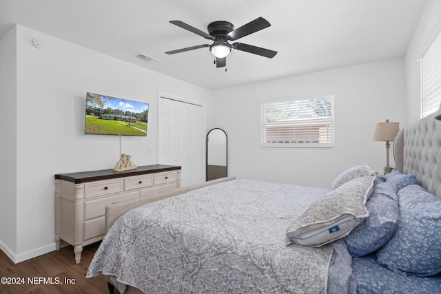 bedroom with ceiling fan, dark hardwood / wood-style floors, and a closet