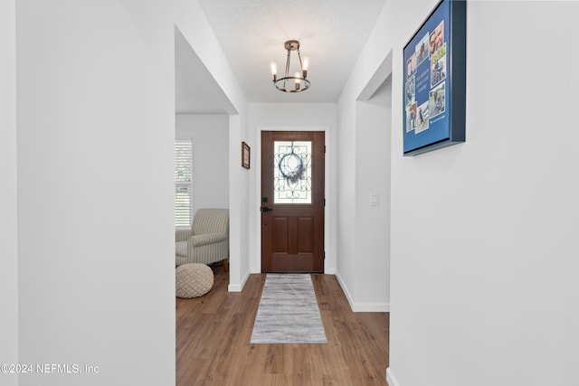 entryway with a chandelier, a textured ceiling, and hardwood / wood-style flooring