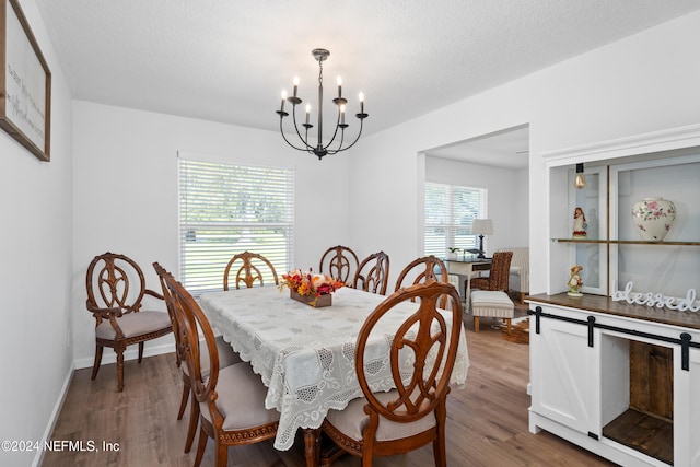 dining space featuring a chandelier, a textured ceiling, and hardwood / wood-style flooring