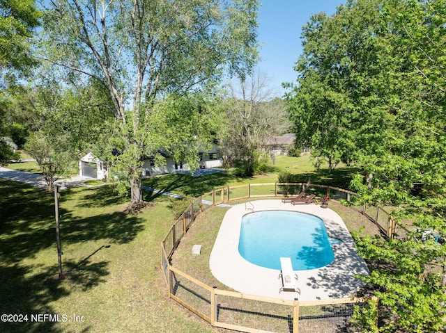 view of swimming pool featuring a diving board and a yard