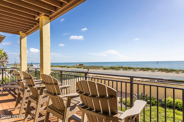 balcony with a water view and a view of the beach