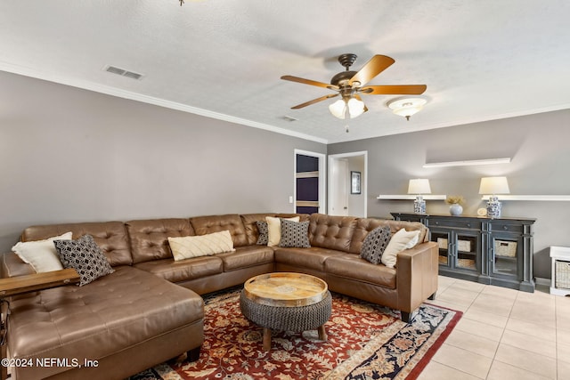 living room with light tile patterned floors, a textured ceiling, ceiling fan, and ornamental molding