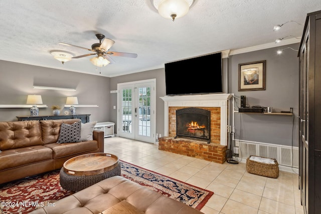 tiled living room featuring ceiling fan, french doors, a brick fireplace, a textured ceiling, and ornamental molding