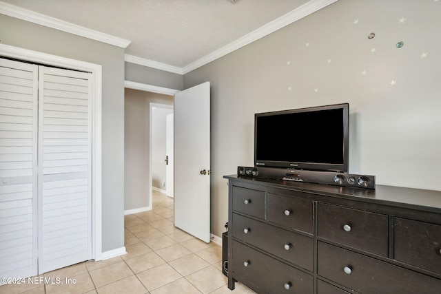 bedroom featuring crown molding, a closet, and light tile patterned flooring