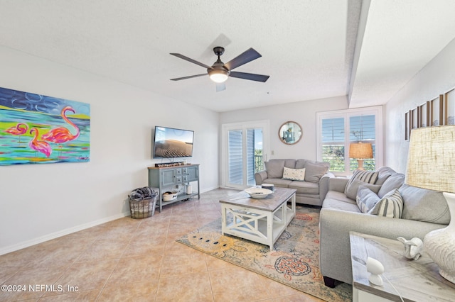 tiled living room with ceiling fan and a textured ceiling