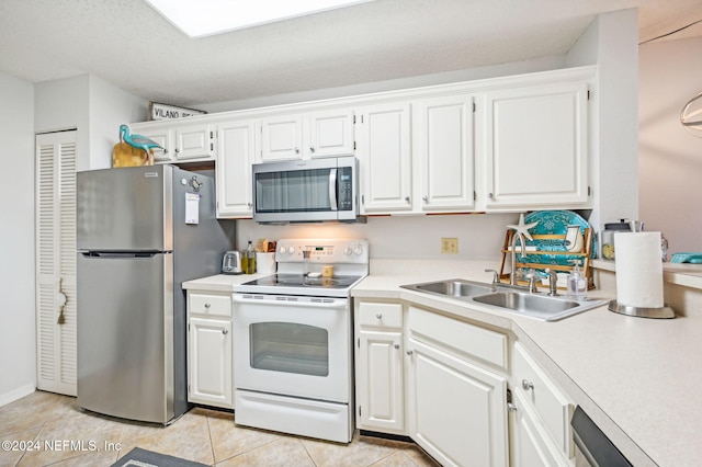 kitchen featuring appliances with stainless steel finishes, white cabinetry, and sink