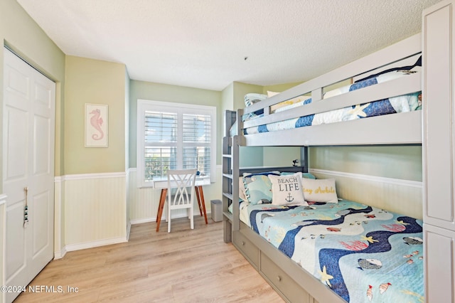 bedroom with light wood-type flooring and a textured ceiling