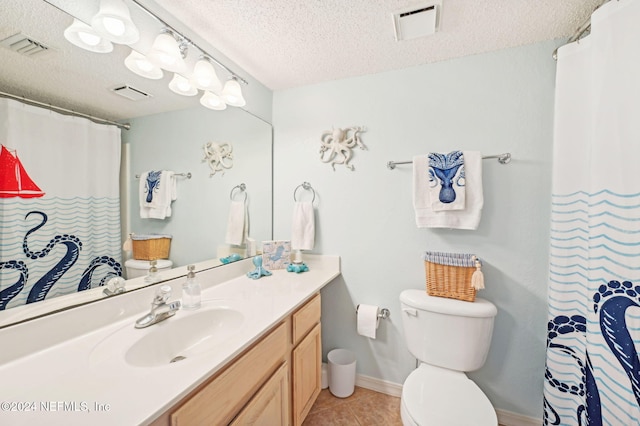 bathroom featuring tile patterned floors, vanity, toilet, and a textured ceiling