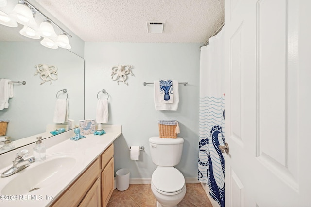 bathroom with tile patterned flooring, vanity, toilet, and a textured ceiling