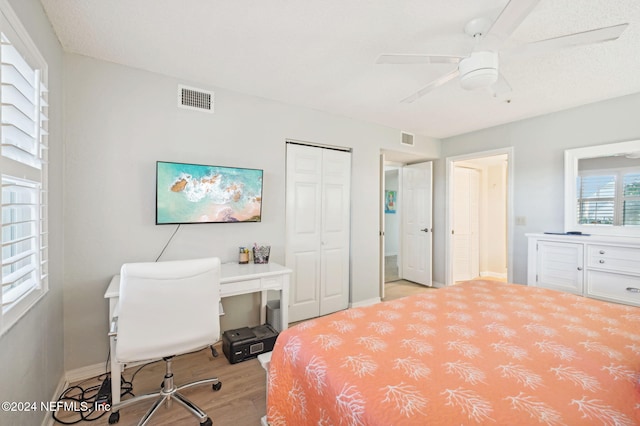 bedroom with ceiling fan, light hardwood / wood-style flooring, and a closet