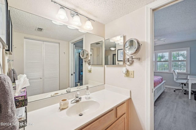 bathroom featuring vanity, a textured ceiling, and hardwood / wood-style flooring