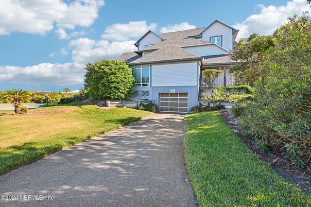 view of front of property featuring a front lawn and a garage