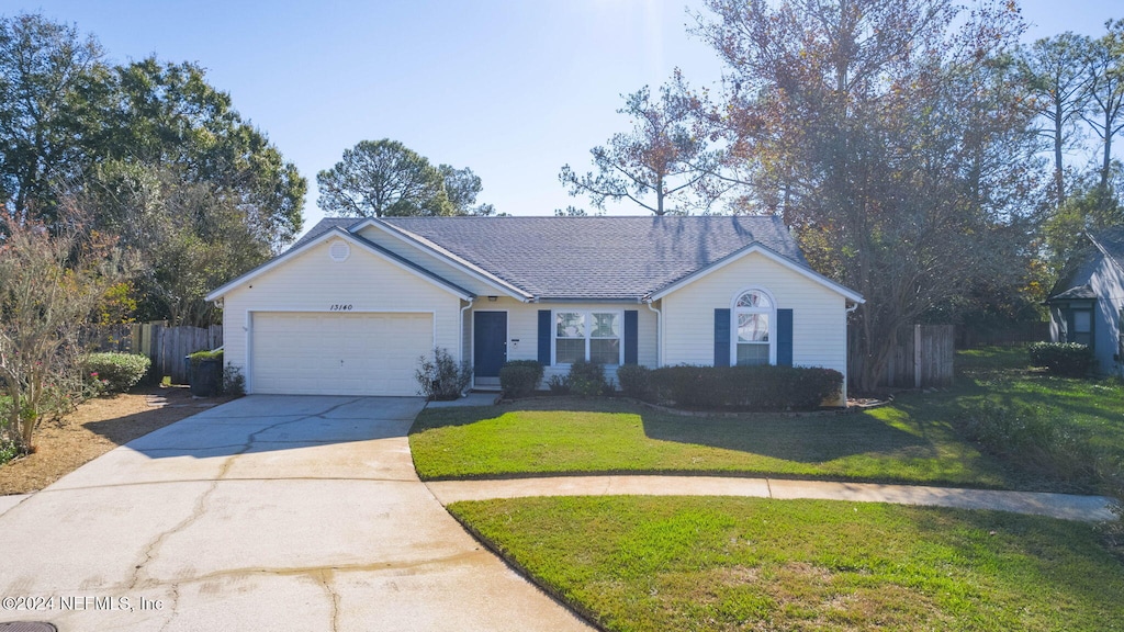 ranch-style home featuring a garage and a front lawn