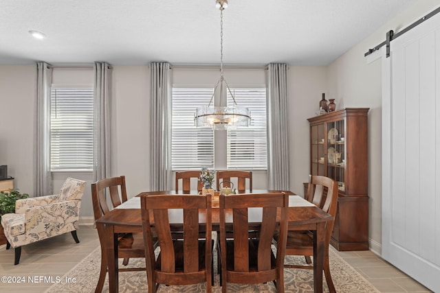 tiled dining area featuring a barn door and a notable chandelier