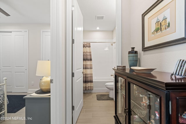 bathroom with shower / bath combo, toilet, and wine cooler