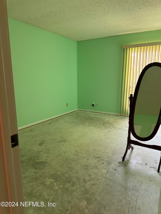 spare room with a textured ceiling