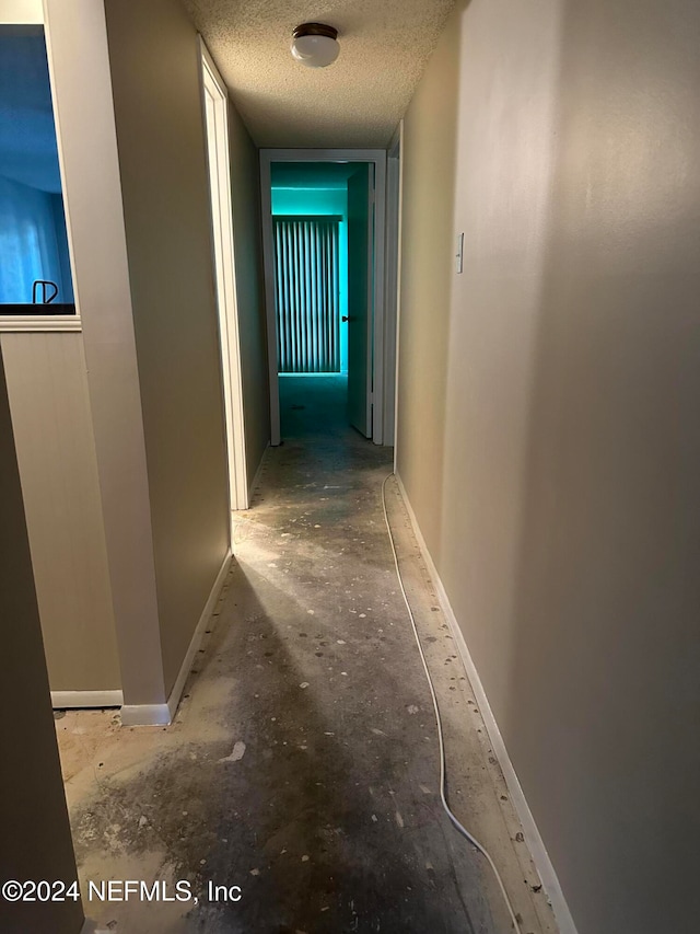 hallway with a textured ceiling