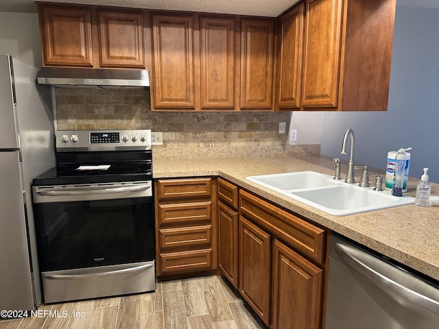 kitchen with decorative backsplash, appliances with stainless steel finishes, and sink