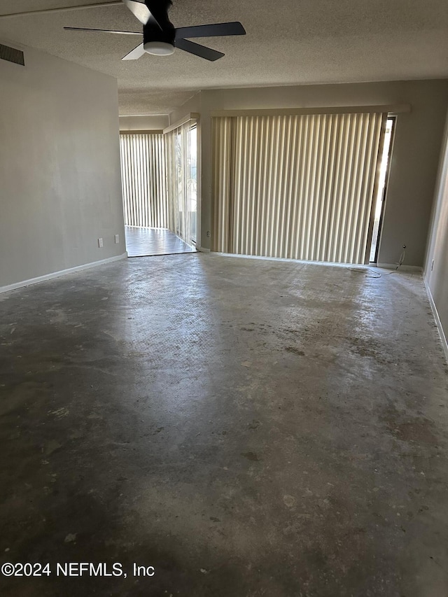 empty room featuring concrete flooring, a textured ceiling, and ceiling fan