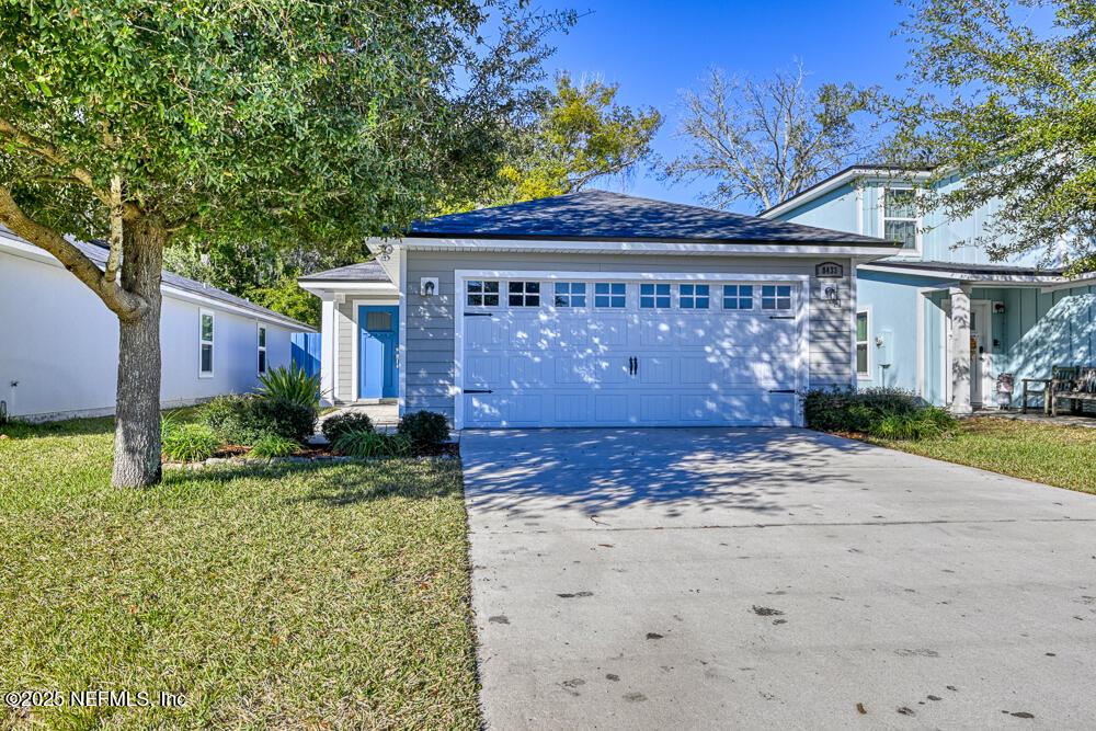 view of front of property with a garage and a front lawn