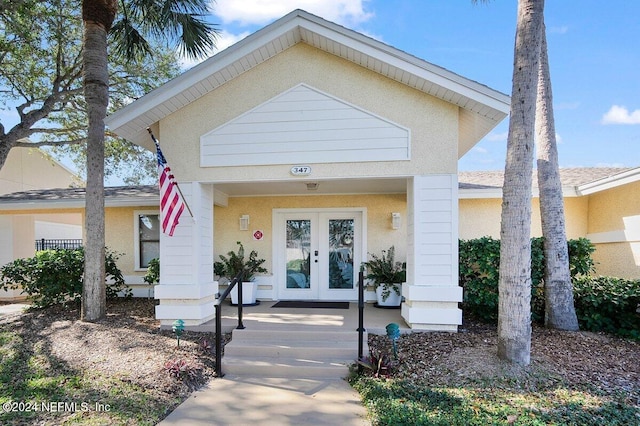 view of front facade with french doors and stucco siding