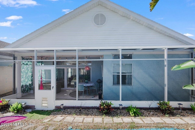 back of property with a sunroom